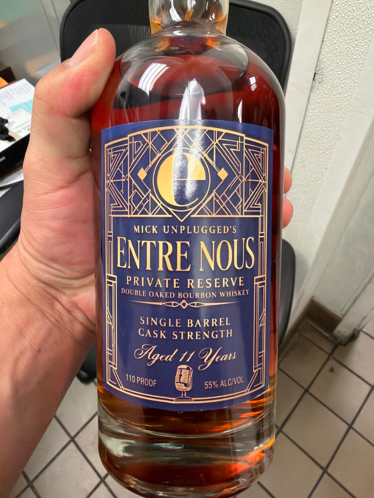 Original photograph of a hand holding Mick Unplugged’s Entre Nous Private Reserve bourbon